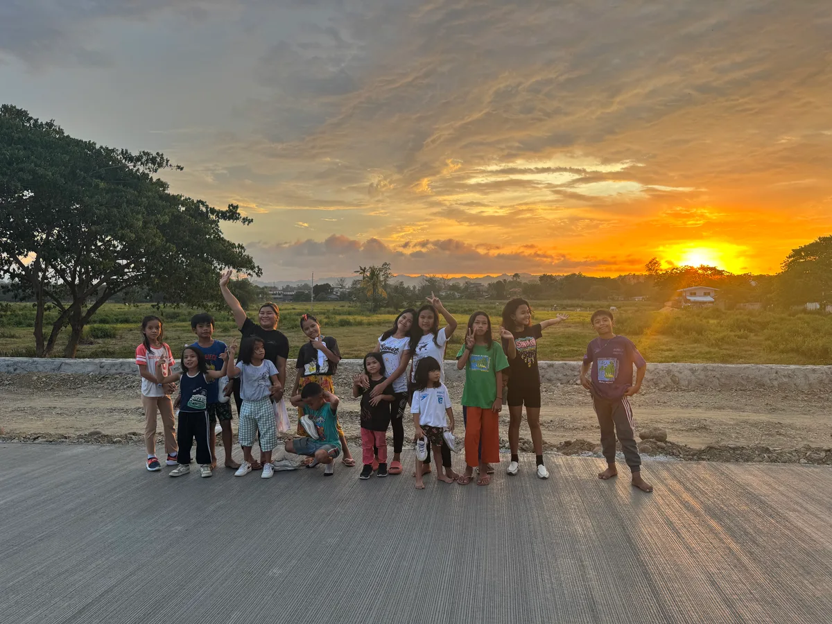 Vor einem wunderschönen Sonnenuntergang geniessen die Kinder des Kinderdorfs ihren Abend. Die Kinder des Kinderdorfs machen ein Gruppenfoto vor dem Sonnenuntergang.